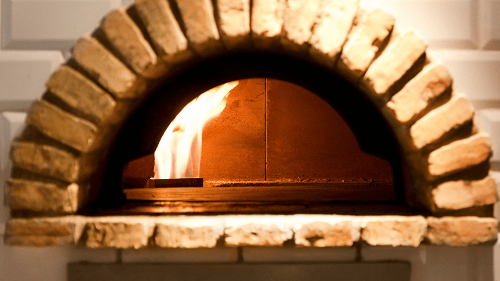 Traditional brick pizza oven with a visible open flame inside, ready for wood-fired cooking. Would you like a more SEO-focused or descriptive version for product listings or blog use?