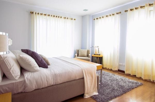 Airy bedroom with white bedding and bright windows