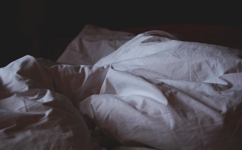 Soft white bedding and blanket on a bed, kept cool for hot summer nights