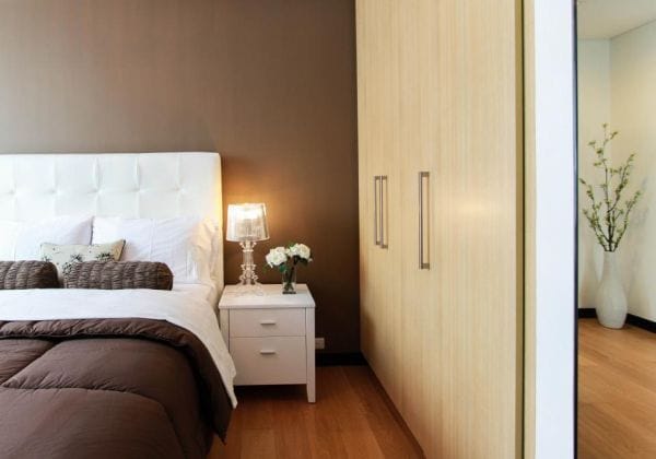 Tidy UK bedroom with a neatly made double bed and white bedding
