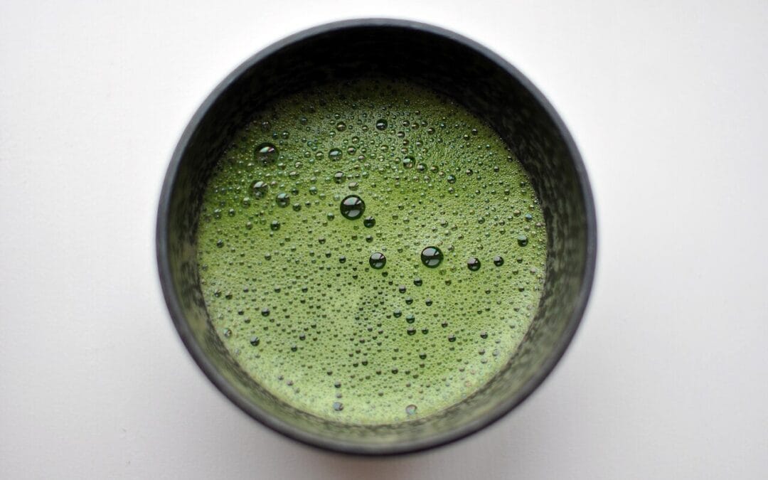 A bowl of bright green whisked matcha green tea