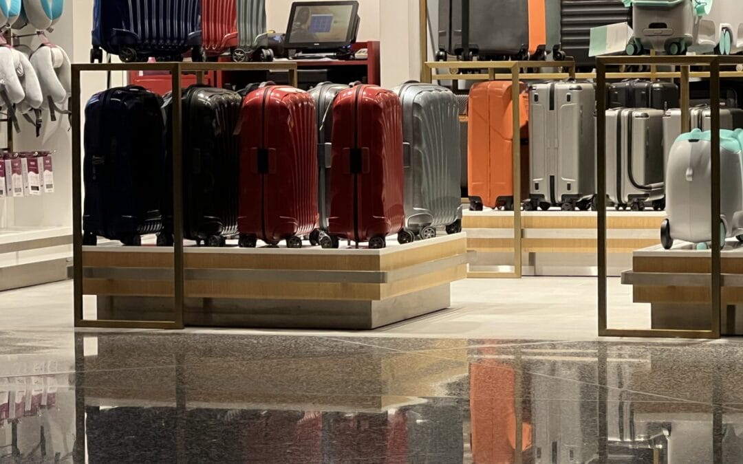 Row of cabin sized hard shell suitcases in an airport terminal