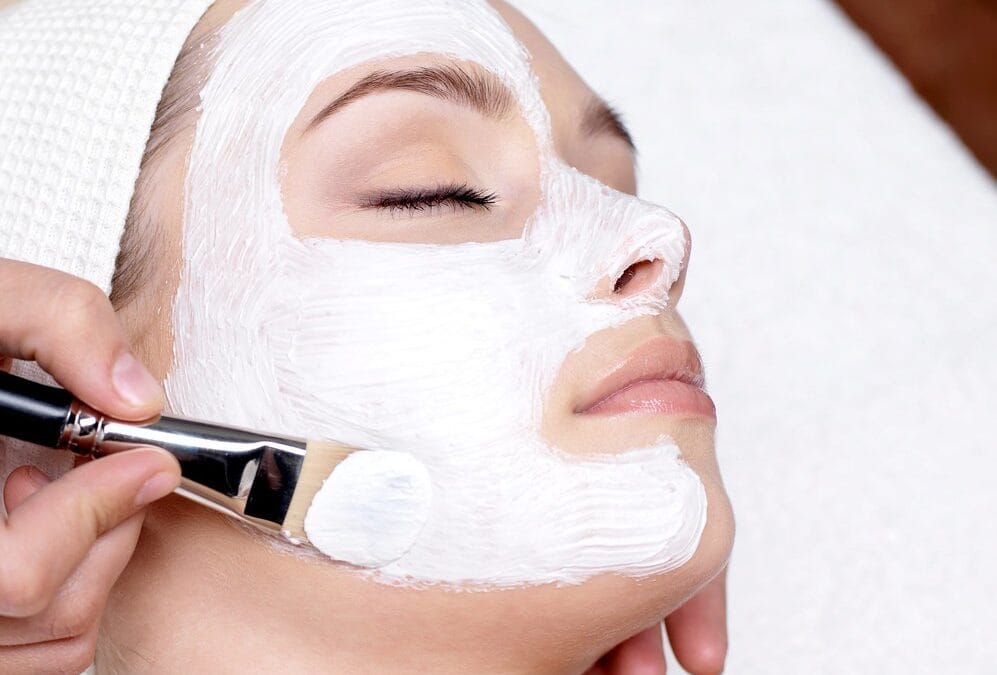 Woman having a face mask applied during a facial skincare treatment