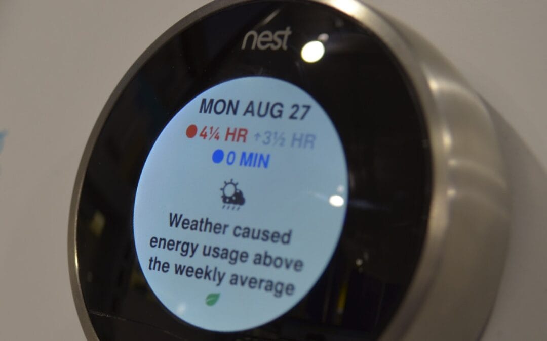 A wall-mounted smart thermostat dial showing a home energy usage message