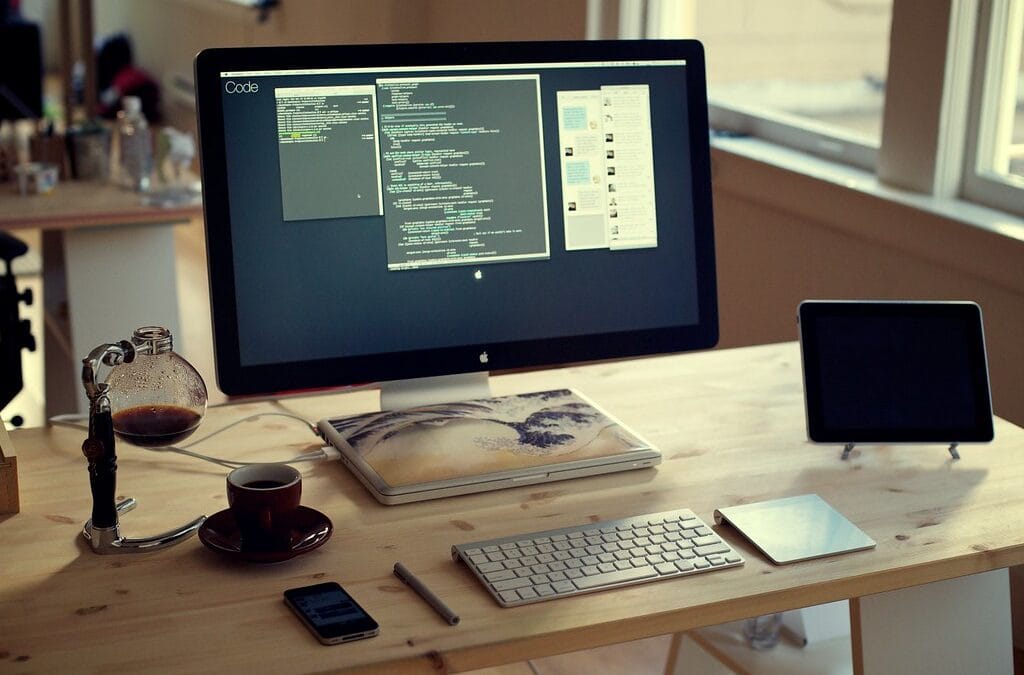 A tidy home desk setup with a large monitor, a laptop and a tablet used as a second screen.