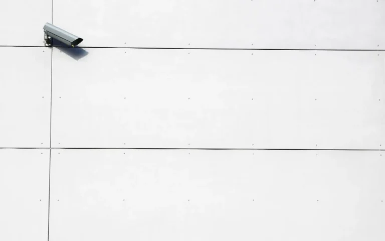 A security camera on a white wall