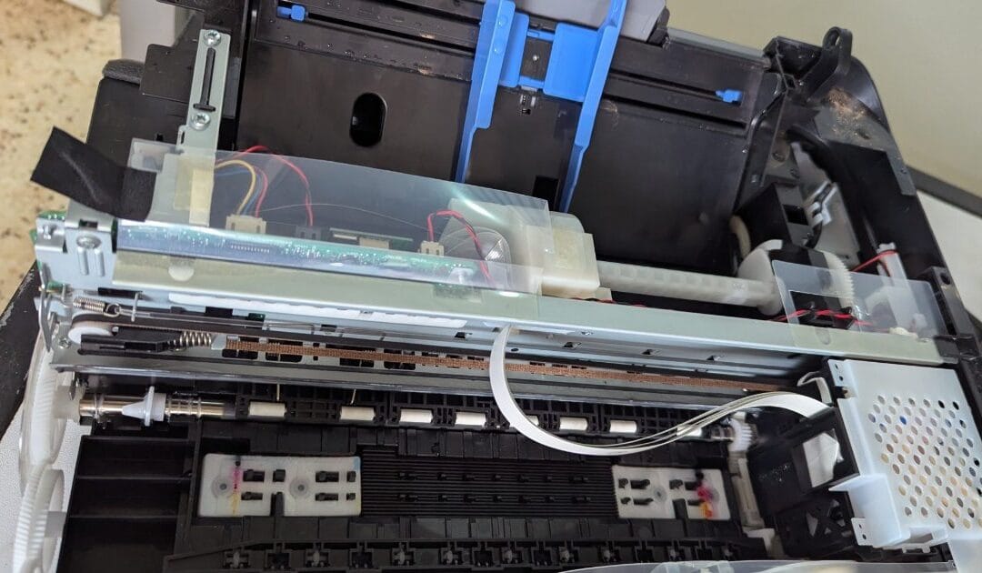 The inside of an opened printer, showing its gears and paper path