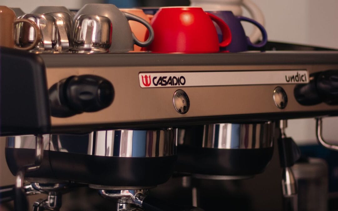 Two-group commercial espresso machine in a cafe with cups warming on top