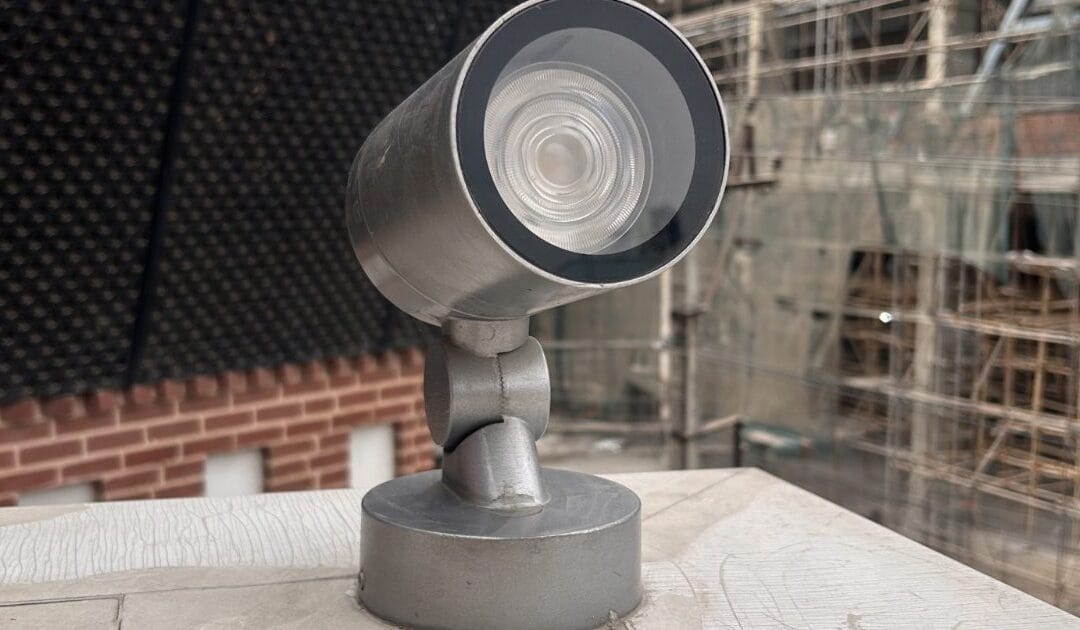 An outdoor security camera mounted on a ledge