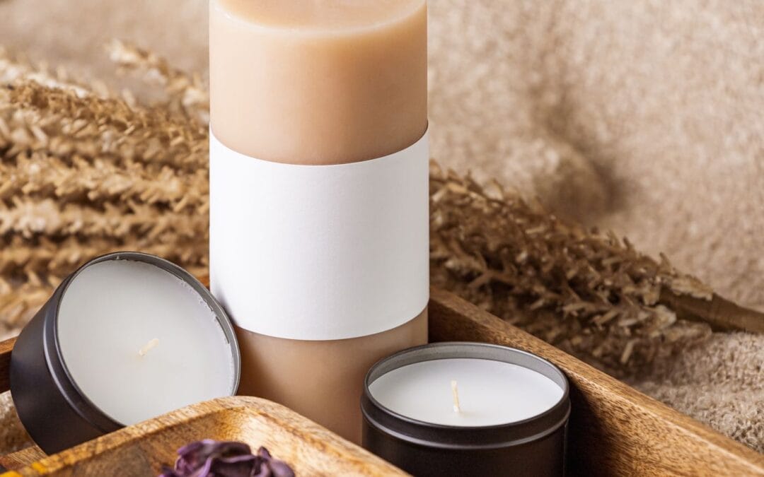 Soy candle jars and tins in a wooden tray with dried autumn grasses