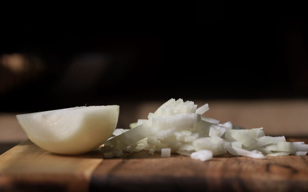 Diced onions on a wooden chopping board