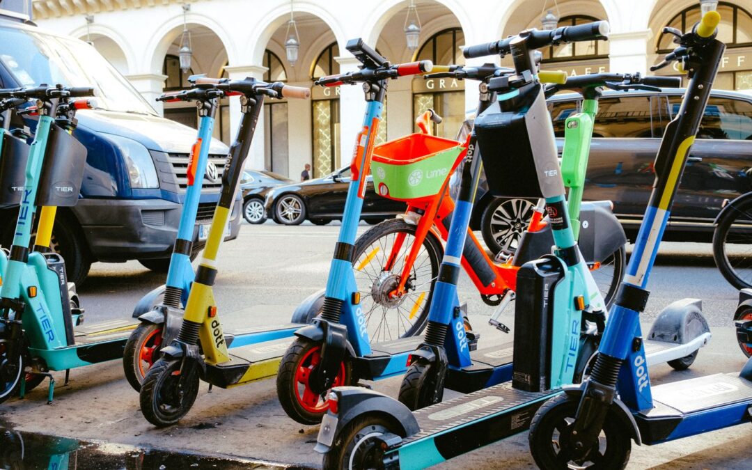 Rental electric scooters and a bicycle parked on a city street