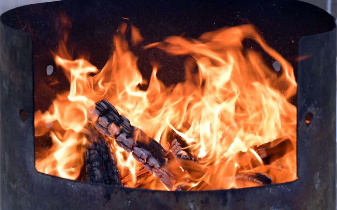 Logs burning in a metal garden fire pit
