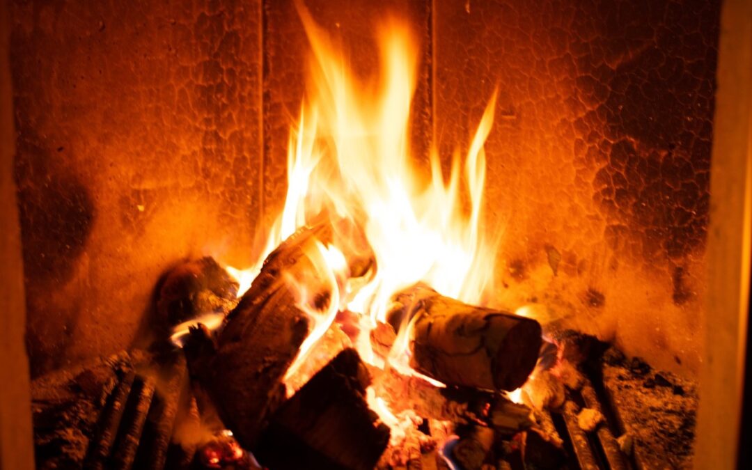 Logs burning with bright flames in a domestic fireplace grate