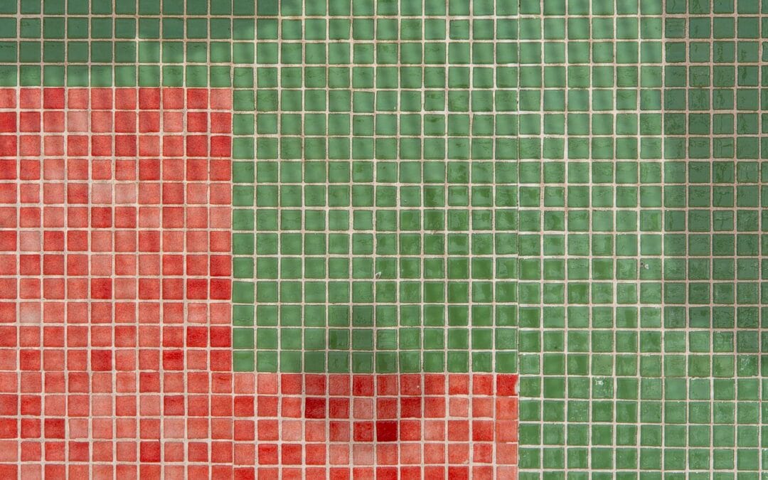 Close up of a tiled bathroom wall showing the grout lines between small square tiles