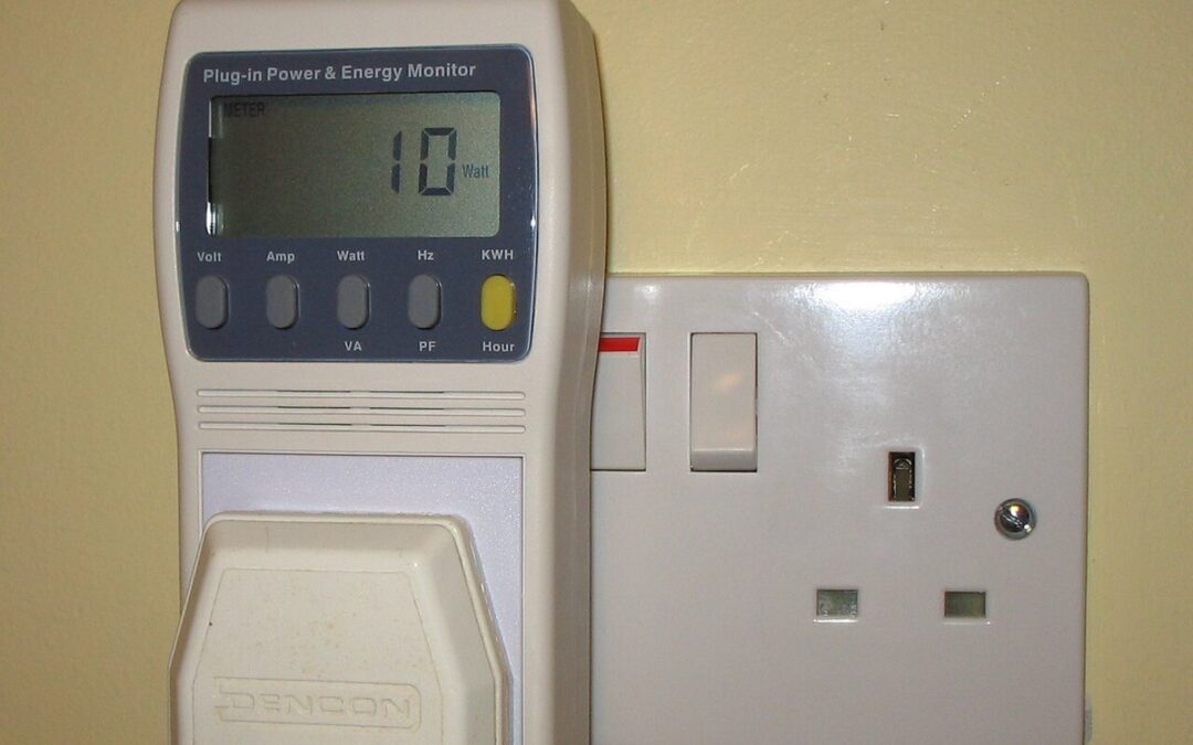 A plug-in power and energy monitor in a UK 13A mains socket, its display reading 10 watts