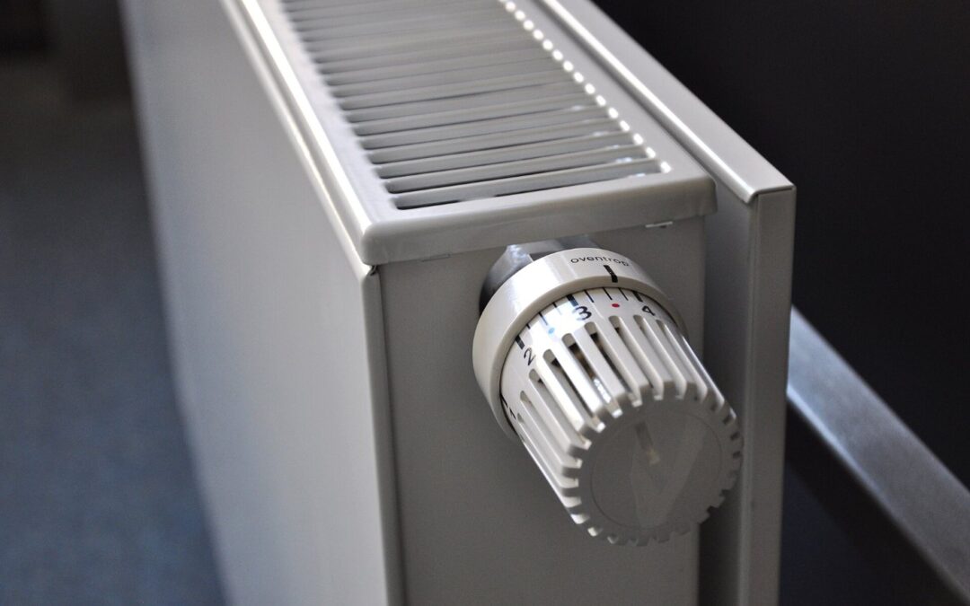 White panel radiator with a thermostatic valve, fitted to a wall
