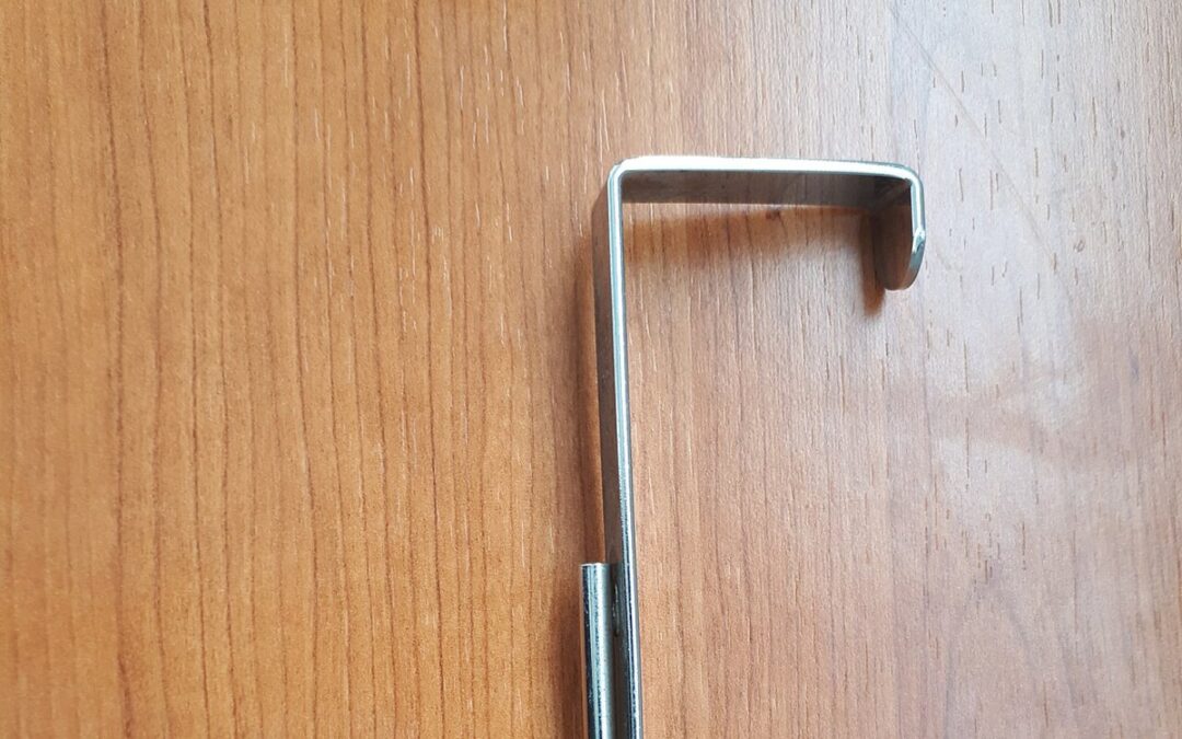 A metal hook fixed to a wooden wall surface
